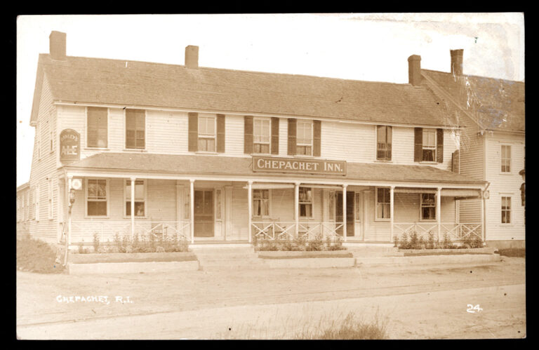 Sepia photo of the street view of an inn with a porch.